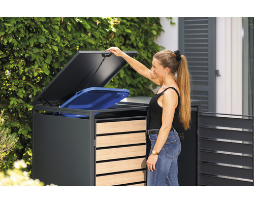 Žena otevírá box na popelnice s modrou popelnicí