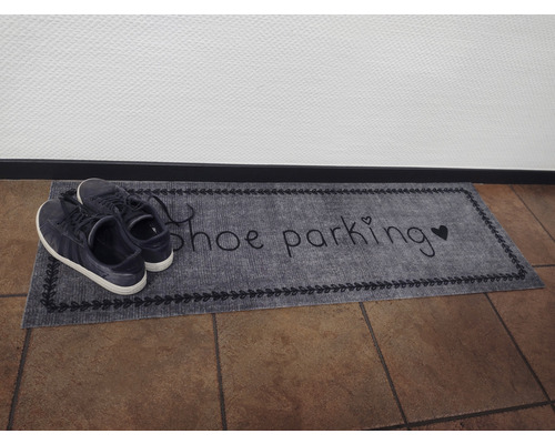 Rohožka s nápisem parkoviště bot a boty na ní