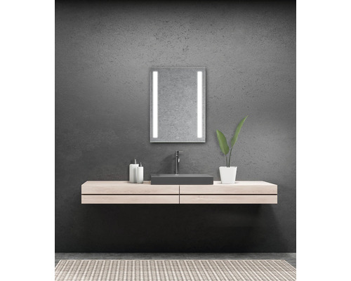 Moderní koupelna s osvětleným zrcadlem, umyvadlem a skříňkou pod umyvadlo