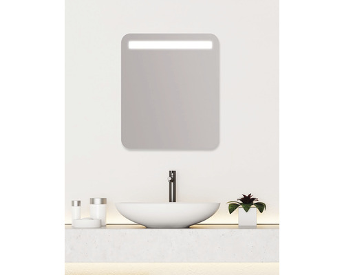 Moderní koupelna s osvětleným zrcadlem, umyvadlem a vodovodní baterií.