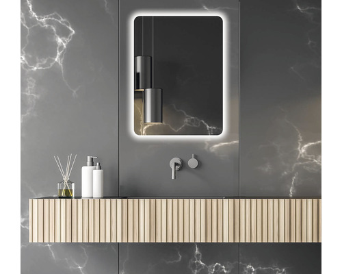 Koupelna s osvětleným zrcadlem, umyvadlovou skříňkou a dekorativními prvky