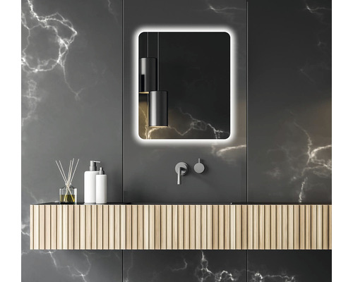 Moderní koupelna s osvětleným zrcadlem, umyvadlem a armaturami na tmavém pozadí