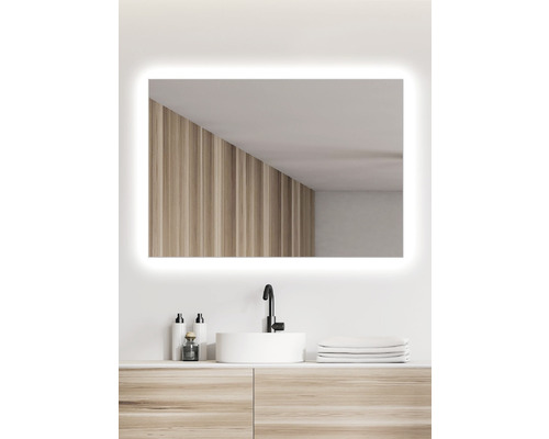 Osvětlené obdélníkové zrcadlo nad umyvadlem v koupelně.