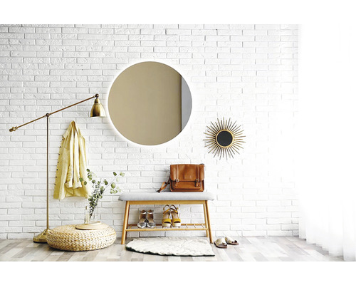 Vstupní prostor se zrcadlem, lavicí, stojací lampou a dekoracemi před bílou cihlovou zdí