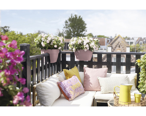 Zdobená balkonová scéna s truhlíky, polštáři a posezením