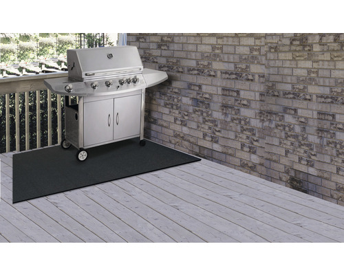 Scéna s plynovým grilem na ochranné podložce na dřevěné terase.