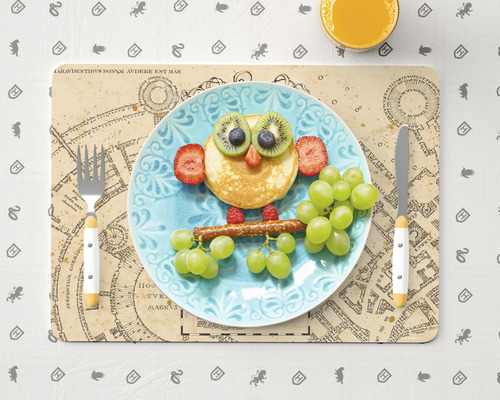 Dekorativně upravený dětský talíř na prostírání s příbory a pomerančovým džusem