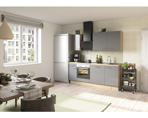 Světlá kuchyně s jídelním stolem, židlemi, kuchyňskou linkou se spotřebiči a kuchyňským vozíkem.