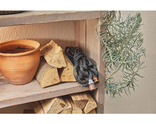 Police s zahradní hadicí, dřevěnými briketami, květináčem a rostlinou