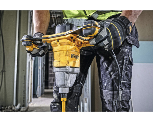 Řemeslník používá žlutý míchací stroj na maltu DeWalt na staveništi.