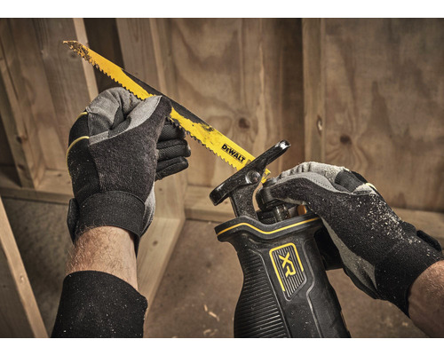 Osoba s pilou ocaskou DeWalt při řezání dřeva