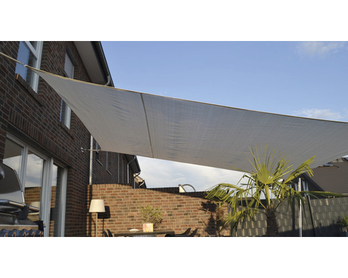 Sluneční plachta na terase s nábytkem a rostlinami