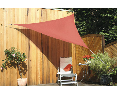 Trojúhelníková sluneční plachta v zahradě se židlí a rostlinami