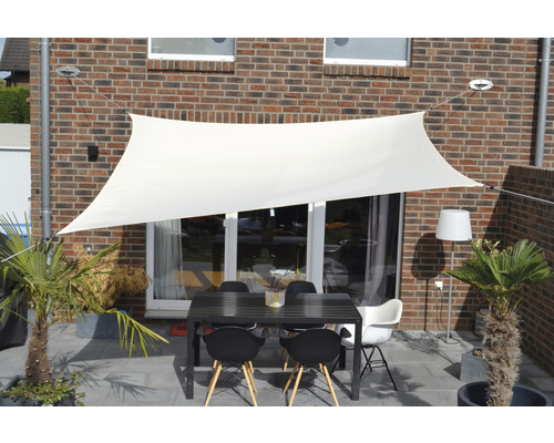 Terasa se sluneční plachtou, stolem a židlemi pro venkovní použití