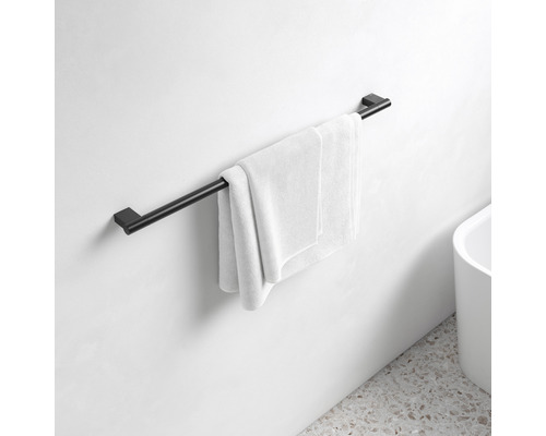Černý držák na ručníky s ručníkem na stěně koupelny