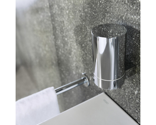 Nástěnný držák na zubní kartáček a držák na ručníky z kovu v koupelně.