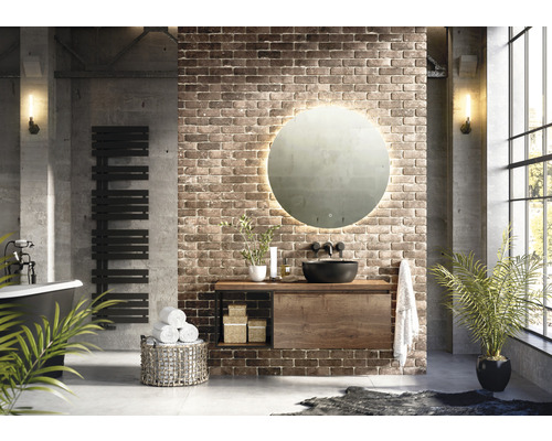 Světlá koupelna s volně stojící vanou, radiátorem na ručníky, umyvadlovou skříňkou se zrcadlem a rostlinami pro příjemnou atmosféru