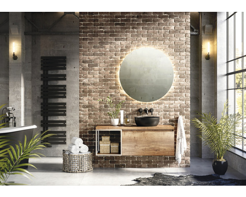 Moderní koupelna s umyvadlem, zrcadlem, topným žebříkem a vanou před cihlovou zdí