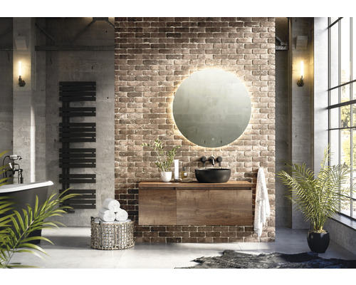 Koupelna v industriálním stylu s umyvadlem, zrcadlem, radiátorem a vanou.