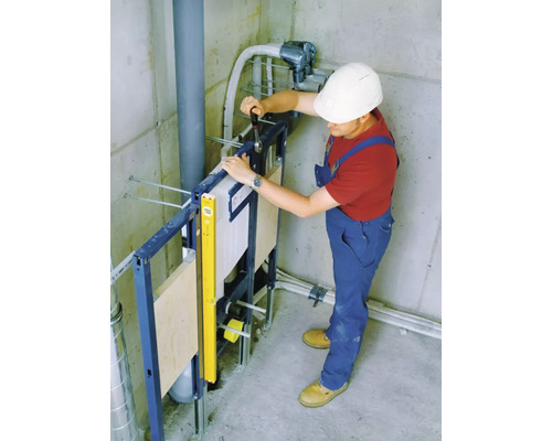 Instalatér montuje předstěnovou instalaci v koupelně.