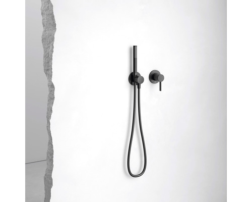 Černá ruční sprcha s hadicí a nástěnnou armaturou na bílé stěně