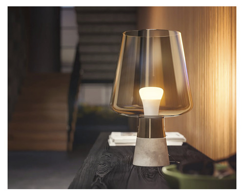 Stolní lampa se skleněným stínidlem a betonovým podstavcem na stole