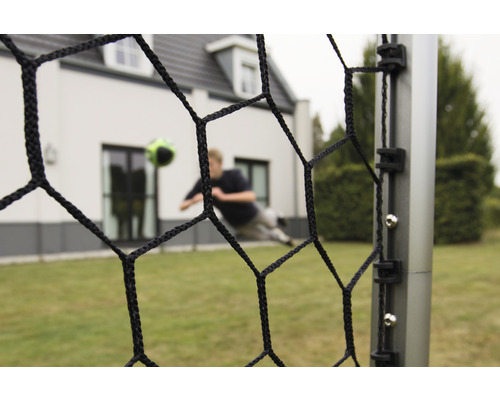 Fotbalová branka se sítí a fotbalistou v pozadí