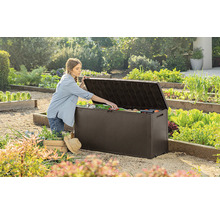 Zahradní scéna s ženou otevírající zahradní box venku a vyndavající zahradní nářadí