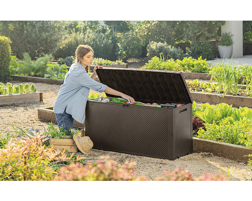 Zahradní scéna s ženou otevírající zahradní box venku a vyndavající zahradní nářadí