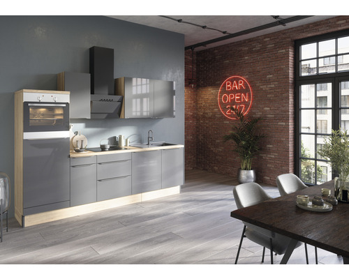 Moderní kuchyně se šedými skříňkami, digestoří a vestavnou troubou ve světlém pokoji s jídelním stolem