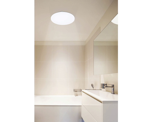 Koupelna s vanou, umyvadlem a kulatým stropním svítidlem