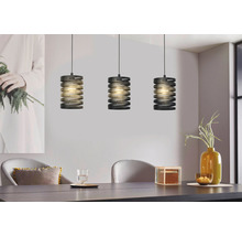 Tři šedé kovové závěsné lampy nad jídelním stolem.