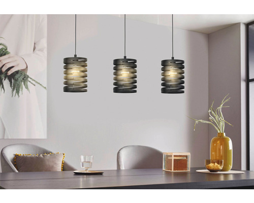 Tři šedé kovové závěsné lampy nad jídelním stolem.