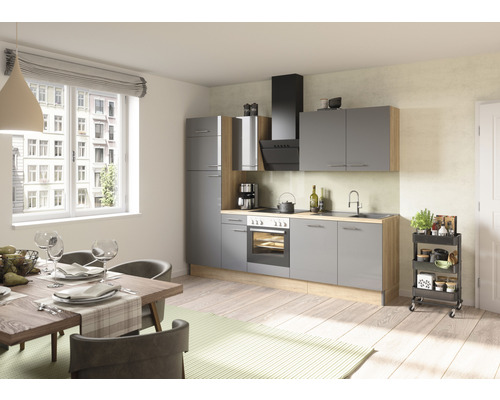 Světlá kuchyně s šedými skříněmi, jídelním stolem a kuchyňským vozíkem.