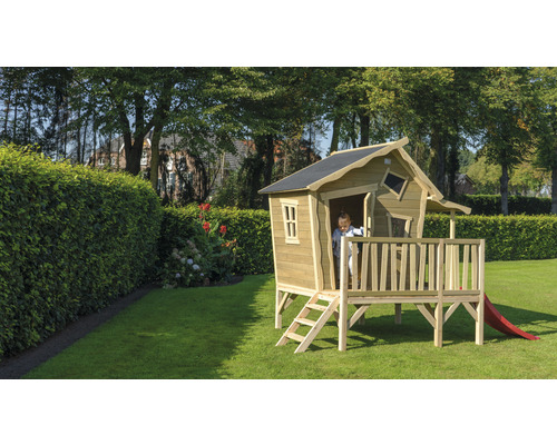 Dřevěný hrací domek se skluzavkou na zahradě