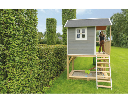 Dětský hrací domek s pískovištěm a žebříkem na zahradě