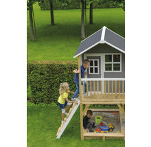 Dětský domek s pískovištěm a hrajícími si dětmi na zahradě.