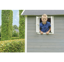 Chlapec vyhlíží z okna dřevěného hracího domku