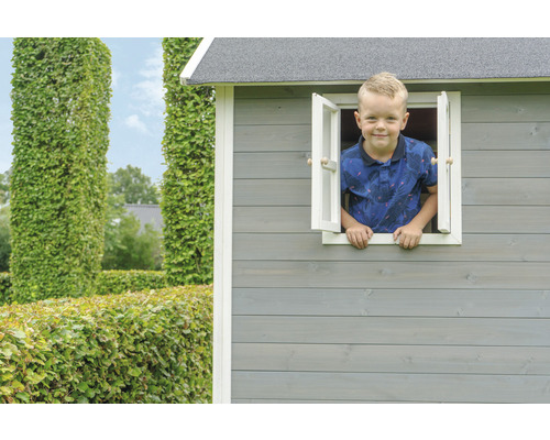 Chlapec vyhlíží z okna dřevěného hracího domku