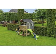 Dětský domek se skluzavkou a pískovištěm na zahradě s hrajícími si dětmi