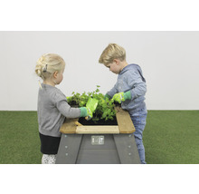 Děti si hrají s vyvýšeným záhonem na zahradě.