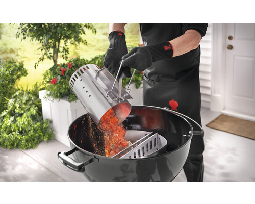 Osoba sype žhavé grilovací uhlí z komínu na zapalování do grilu na dřevěné uhlí