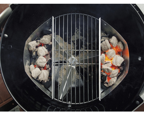 Gril s koši na uhlí a žhnoucími grilovacími briketami pod grilovací mřížkou