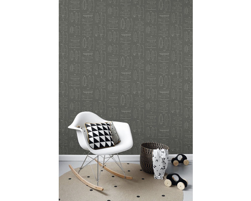 Pohled do místnosti s tapetou s grafickým vzorem, houpacím křeslem a doplňky