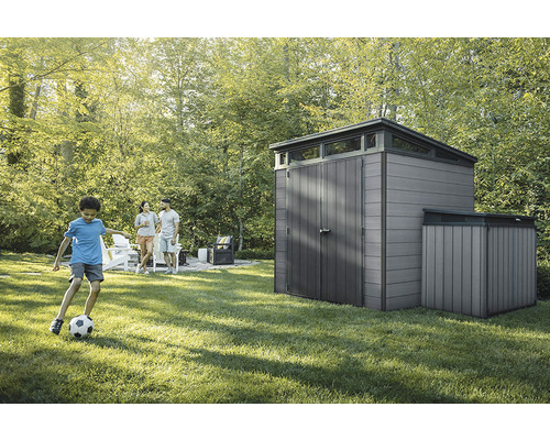 Zahradní scéna s zahradním domkem a hrajícím si dítětem na trávníku