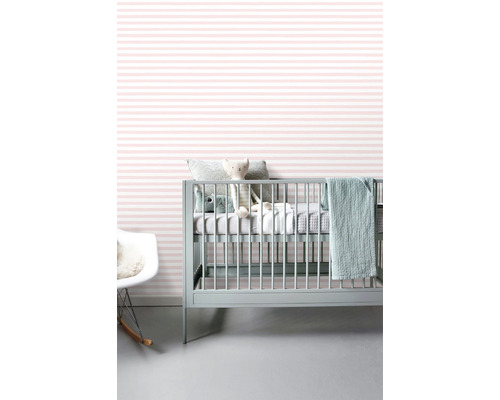 Dětský pokoj s postýlkou, hračkami a pruhovanou tapetou