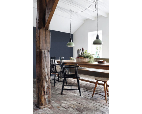 Světlá jídelna s dřevěnými trámy, jídelním stolem a závěsnými svítidly