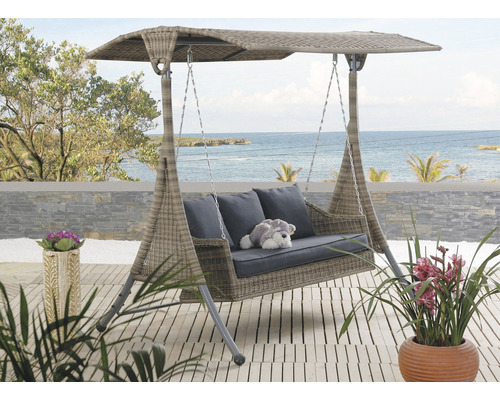 Zahradní houpačka se stříškou, polštáře a plyšová hračka na terase s výhledem na moře