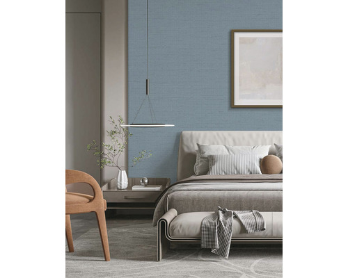 Ložnice s postelí, nočním stolkem a modrou textilní tapetou