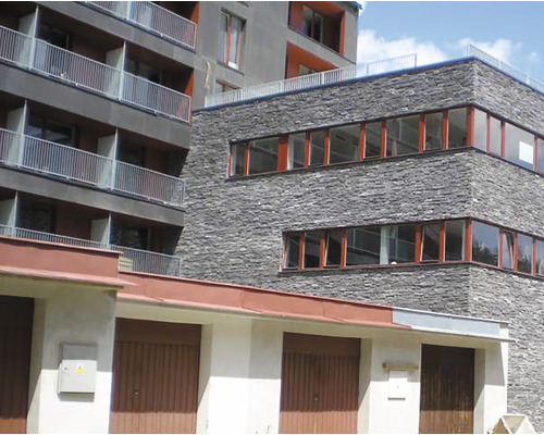 Pohled na bytový dům s garážemi